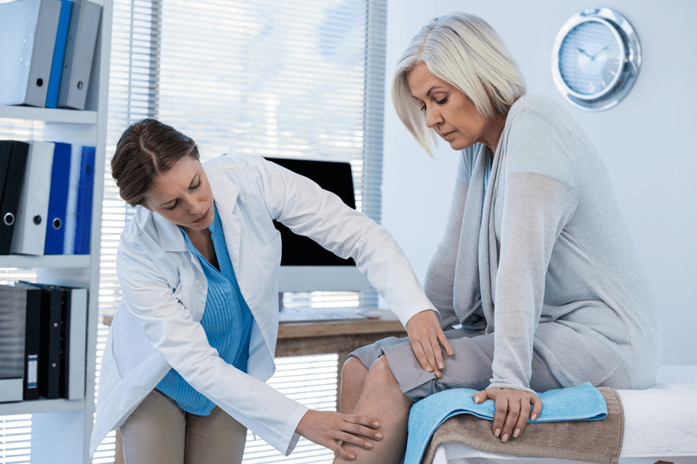 Ο γιατρός εξετάζει έναν ασθενή με αρθρίτιδα της άρθρωσης του γόνατος